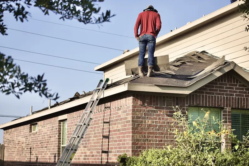 Professional roofer working on a residential roof in Mid-Govans
